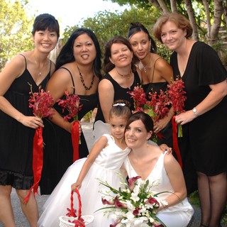 Bridal Party Poses in Black Dresses with Red Bouquets