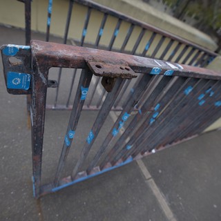 Rusted Metal Railing with Blue Accents on Urban Bridge