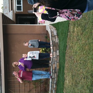 Family Waving Hello Outside Their Home
