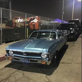 Blue Muscle Car Parked in Front of Fence