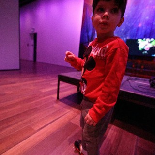 Young Boy Dancing at Purple-Lit Baby Rave Event