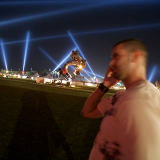 Man on Cell Phone in Front of Statue at Coachella