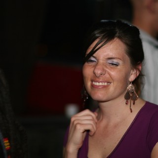 Joyful Woman Smiling at Nighttime Social Gathering