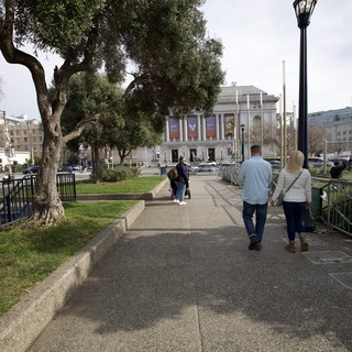 Couple Walking Through Urban Park Toward Museum