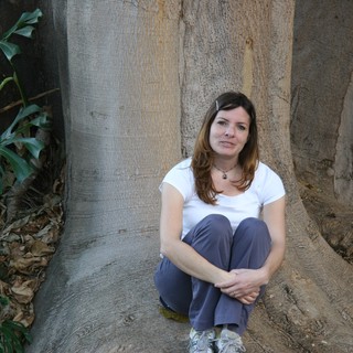 Woman Resting Against Massive Tropical Tree Roots