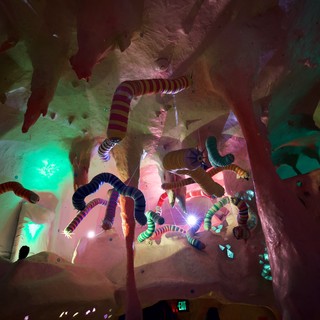 Whimsical Serpent Installation in Illuminated Cave Environment