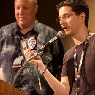 Two Men Speak at Podium with Microphones