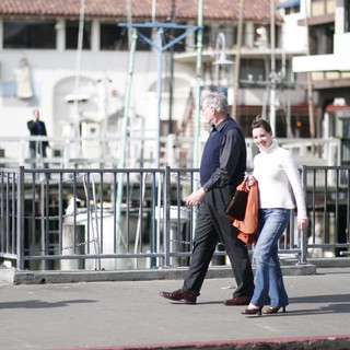 Couple Walking Along Waterfront Promenade in Bright Sunlight