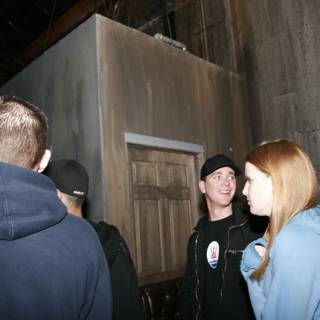 Four People Standing Outside A Door