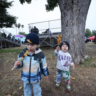 Two Toddlers Enjoying Fruit Skewers at Balloon Festival