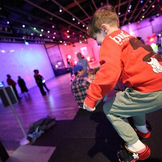 Child Dancing at Baby Rave Event Under Purple Lights