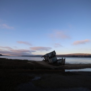 Abandoned Shipwreck at Twilight on Coastal Shore