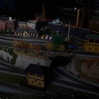 A Diorama of a Train Station with a Miniature Train Moving Along the Tracks
