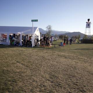The Coachella 2012 Crowd Gathers in a Field with Blue Skies