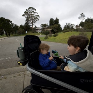 Two Children in Stroller on Suburban Street