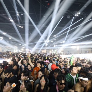 Massive Indoor Rave Crowd Bathed in Laser Beams