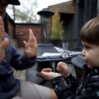 Father and Children Playing Hand Counting Game Outdoors