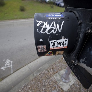 Sticker-Covered Black Mailbox in Suburban Setting