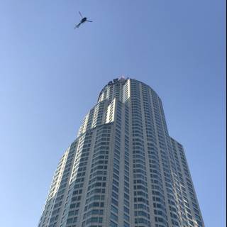 Helicopter Flying Above Highrise Building in Urban Metropolis