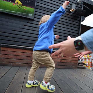 Child Celebrating Soccer Goal on Outdoor Deck