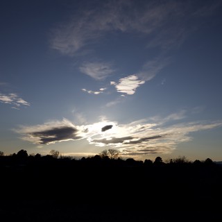 Dramatic Cloud Formation at Sunset Over Silhouetted Landscape