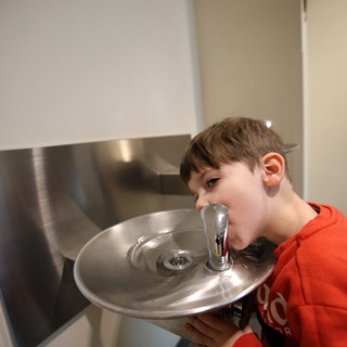 Young Boy Drinking from Water Fountain at Museum