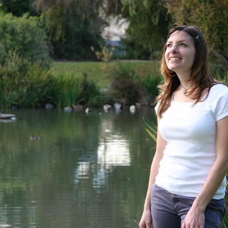Smiling Woman by a Tranquil Park Pond