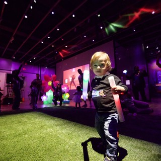 Young Child at Baby Rave Event with Glow Stick