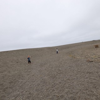 Children Exploring a Vast Dark Sand Dune