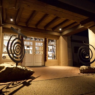 Spiral Sculptures Flanking Illuminated Adobe Entrance at Night