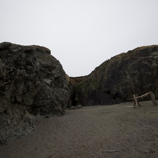 Dark Volcanic Cliffs Frame a Moody Coastal Cove