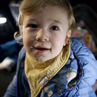 Joyful Toddler in Blue Dinosaur Jacket Smiling at Camera