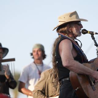Cowboy crooner strums under sunny skies