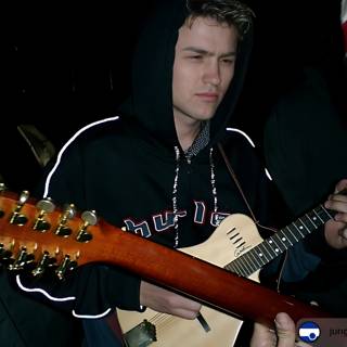 Ansel Elgort playing his acoustic guitar at Coachella