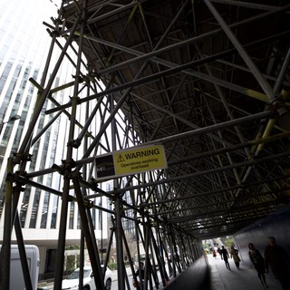 Urban Scaffolding Tunnel with Overhead Warning Sign
