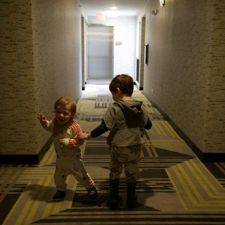 Two Young Children Playing in Hotel Corridor