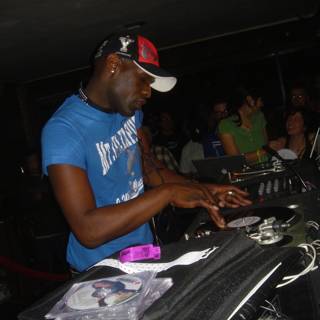 Blue-shirted man working the turntables in a nightclub