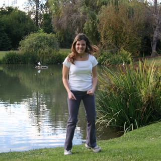 Woman Smiling by a Tranquil Park Pond