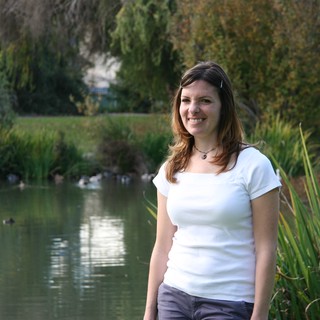 Smiling Woman by a Tranquil Park Pond