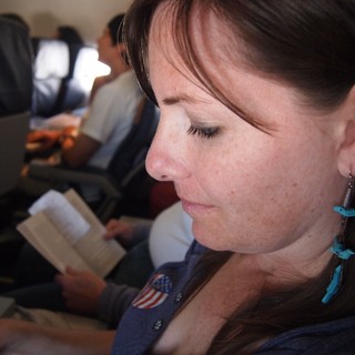 Quiet Reflection: Woman Reading Aboard a Flight