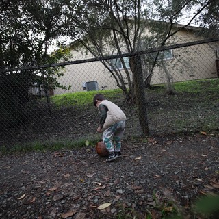 Child Playing Basketball in Suburban Backyard