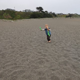 Joyful Toddler Playing with Boomerang on Foggy Beach