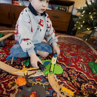 Young Boy Playing with Wooden Train Set on Christmas