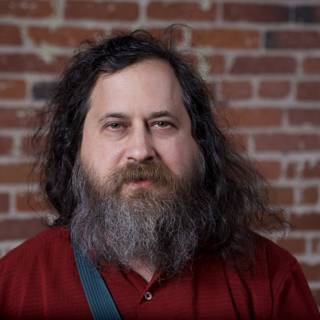 Richard Stallman Poses in Front of Brick Wall