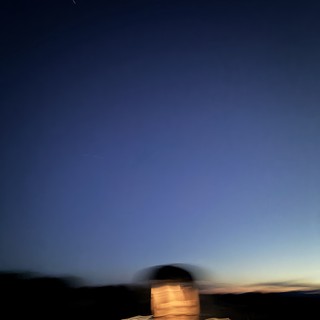 Motion-Blurred Self-Portrait at Twilight Over Desert Landscape