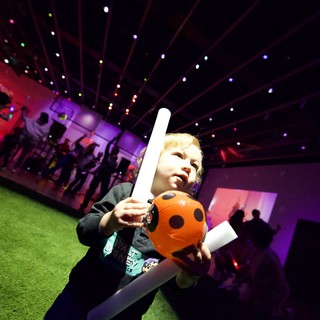 Young Child Enjoying Halloween-Themed Baby Rave with Light Sword