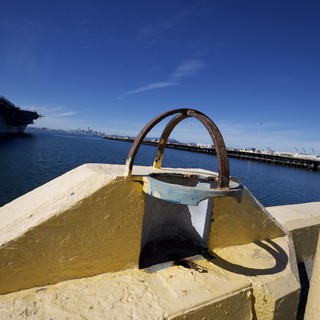 Rusted Mooring Bollard on Yellow Pier at Harbor