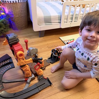 Happy Toddler Playing with Train Set on Christmas Morning