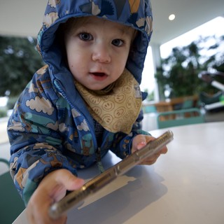 Toddler in Blue Patterned Raincoat at Restaurant