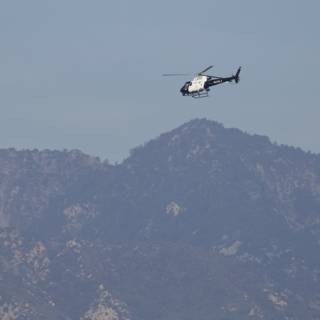 Soaring Majesty: Helicopter Over Mountain Range